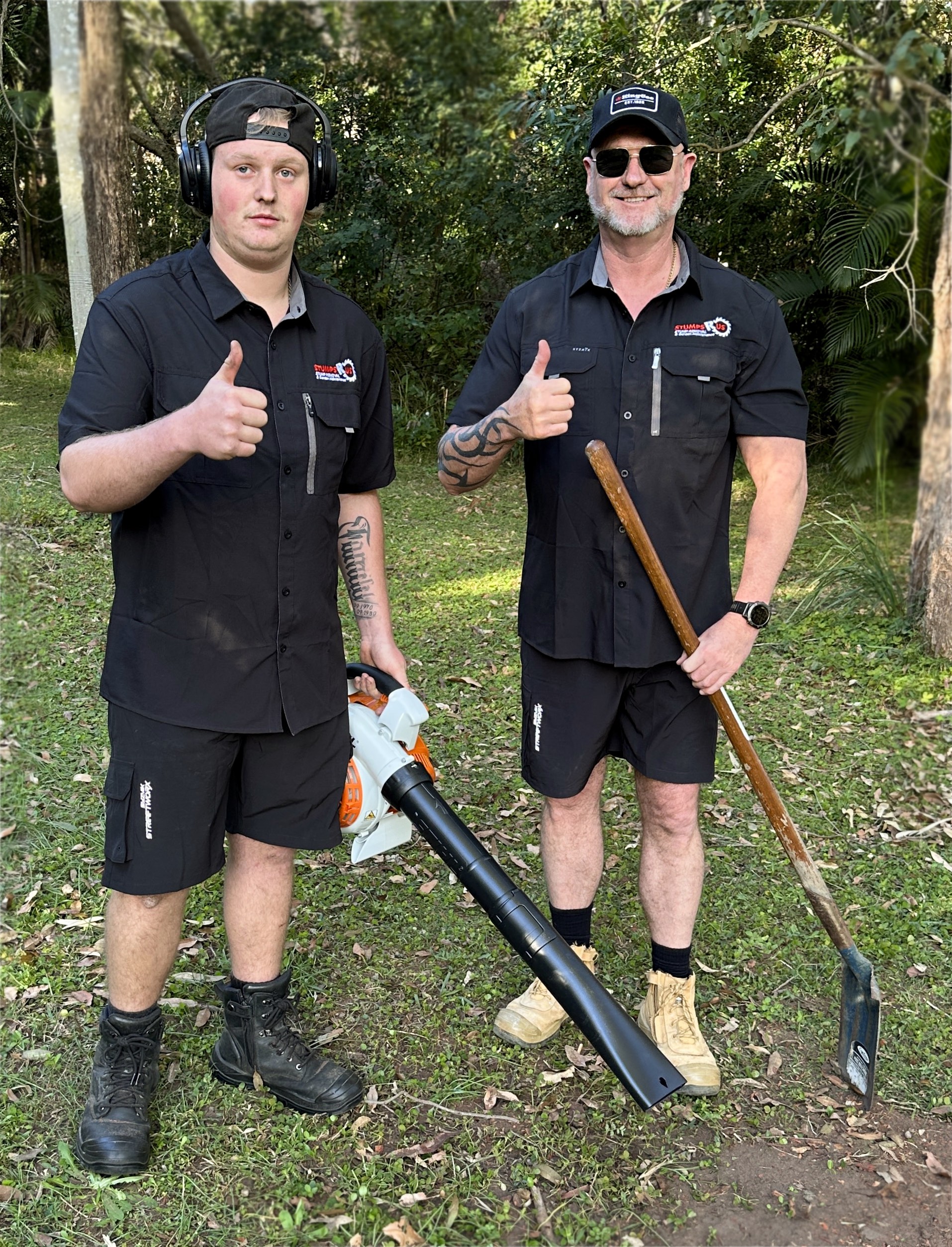 Ray and Leroy from Stumps R Us standing beside their stump grinding machine